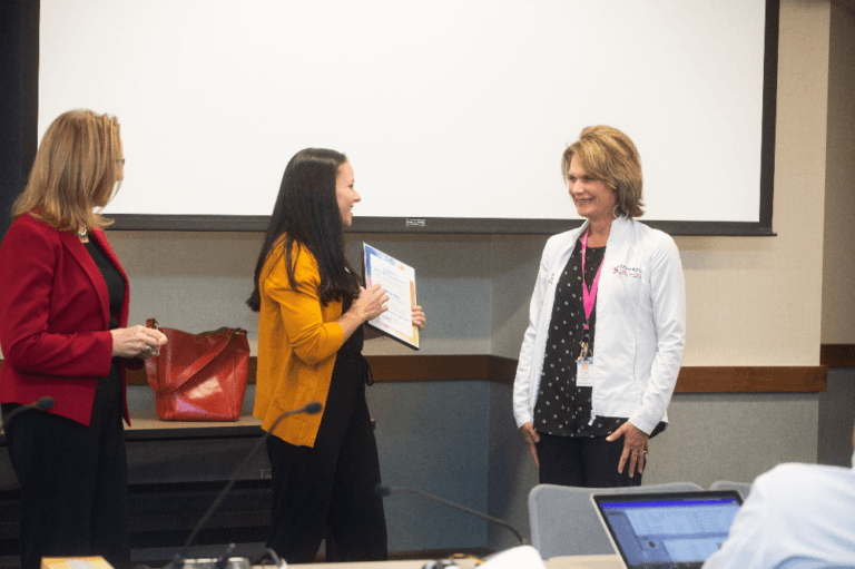 Gloria Top receiving a Guardian Angel pin and certificate