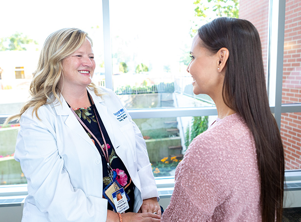 a medical professional and a patient smiling at each other outside