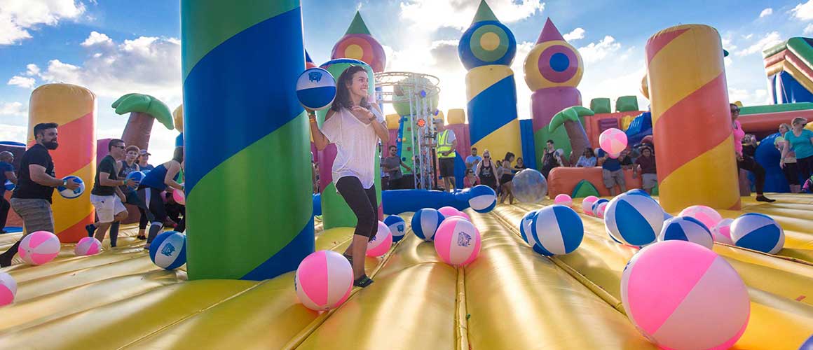 Woman throwing beach ball on oversized bounce house