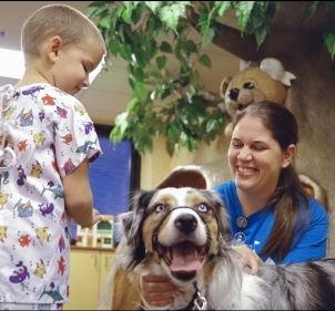 Nurse and patient playing with a dog